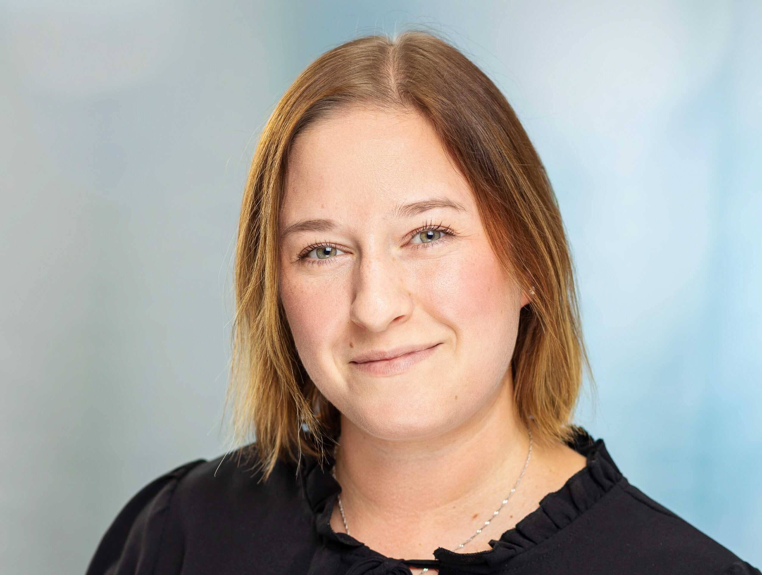 L&auml;chelnde Frau in schwarzem Hemd