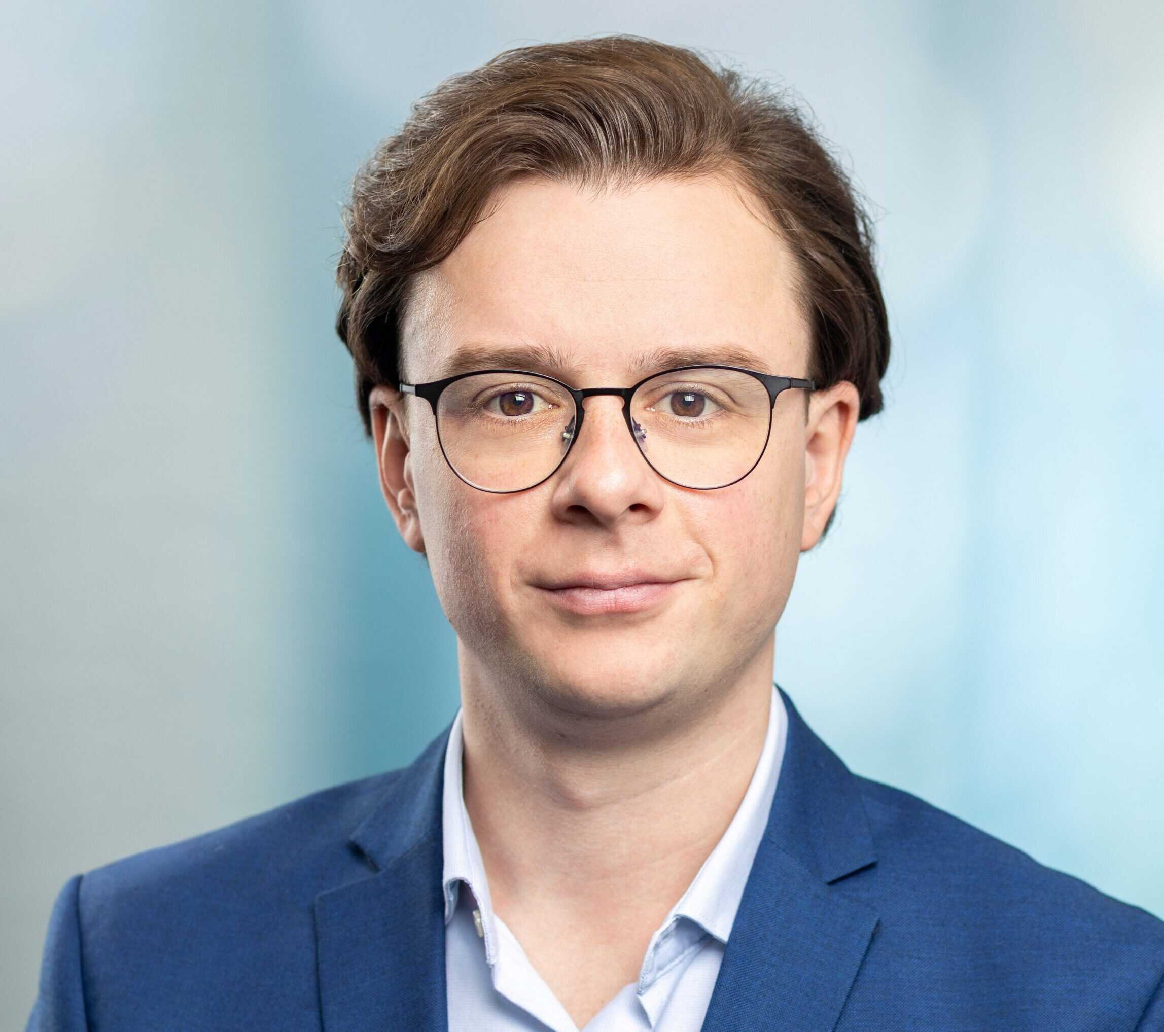 Mann mit Brille und blauem Anzug