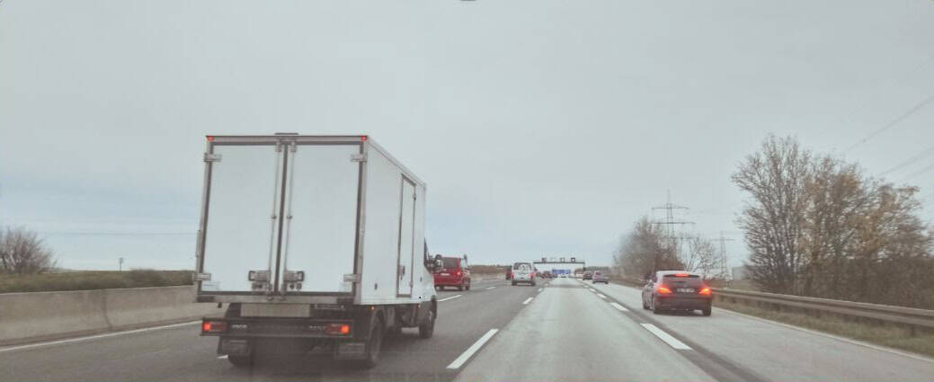 Autobahn mit LKW und Autos.